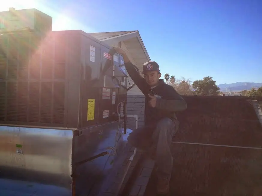 HVAC technician performing Boiler Repair on a rooftop unit in Northfield